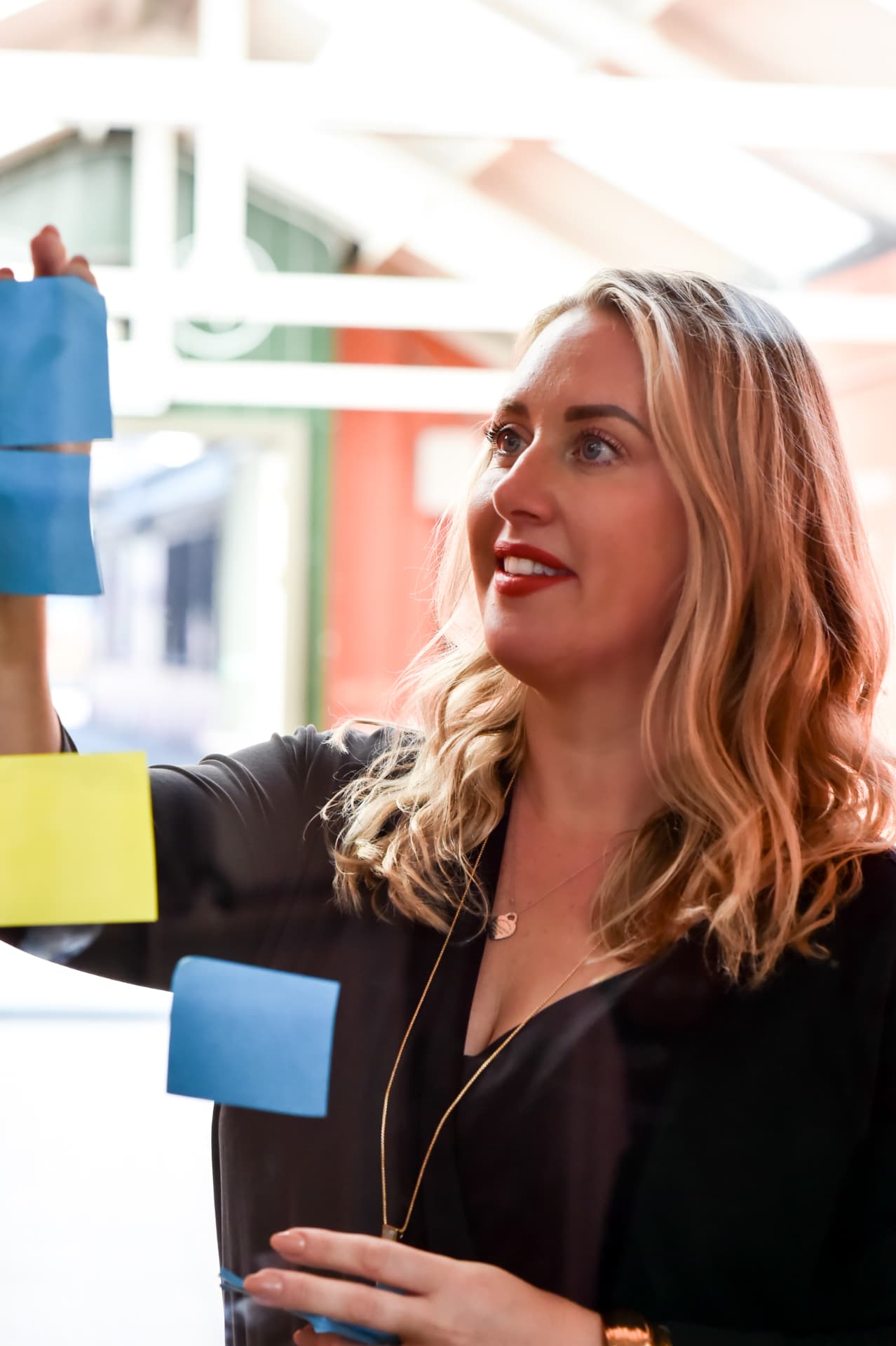 A coach mapping a plan with sticky notes on a glass board